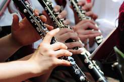 Playing wind instruments produces less viral load than speaking or singing because the instruments act like a filter for larger particles. Additionally, a filter for the instrument and wearing FFP2 masks can minimize the risk of infection.